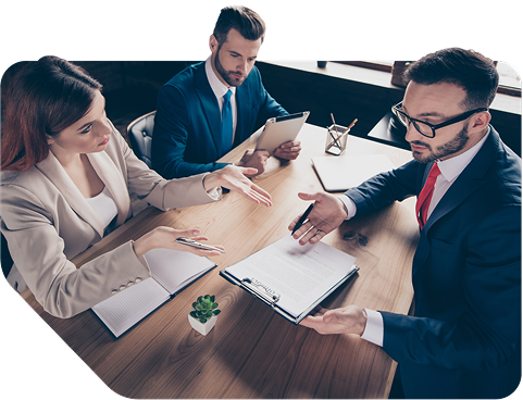 Three people in suits reviewing a legal document